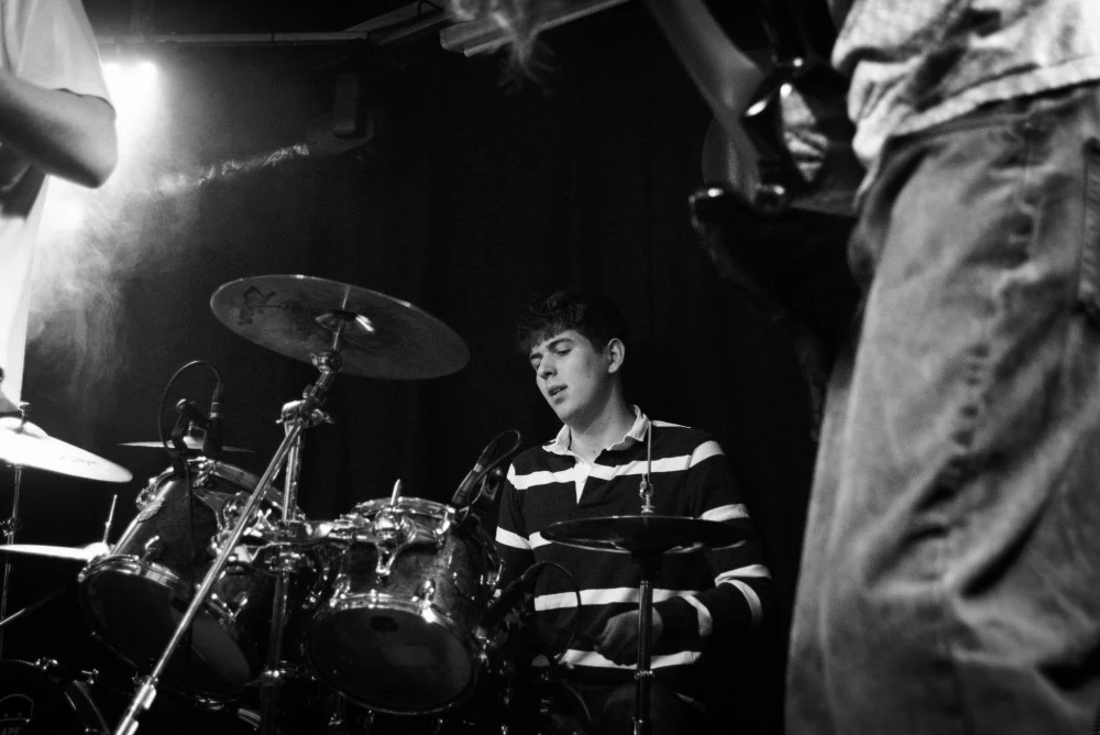 Harry Brenton playing drums on stage