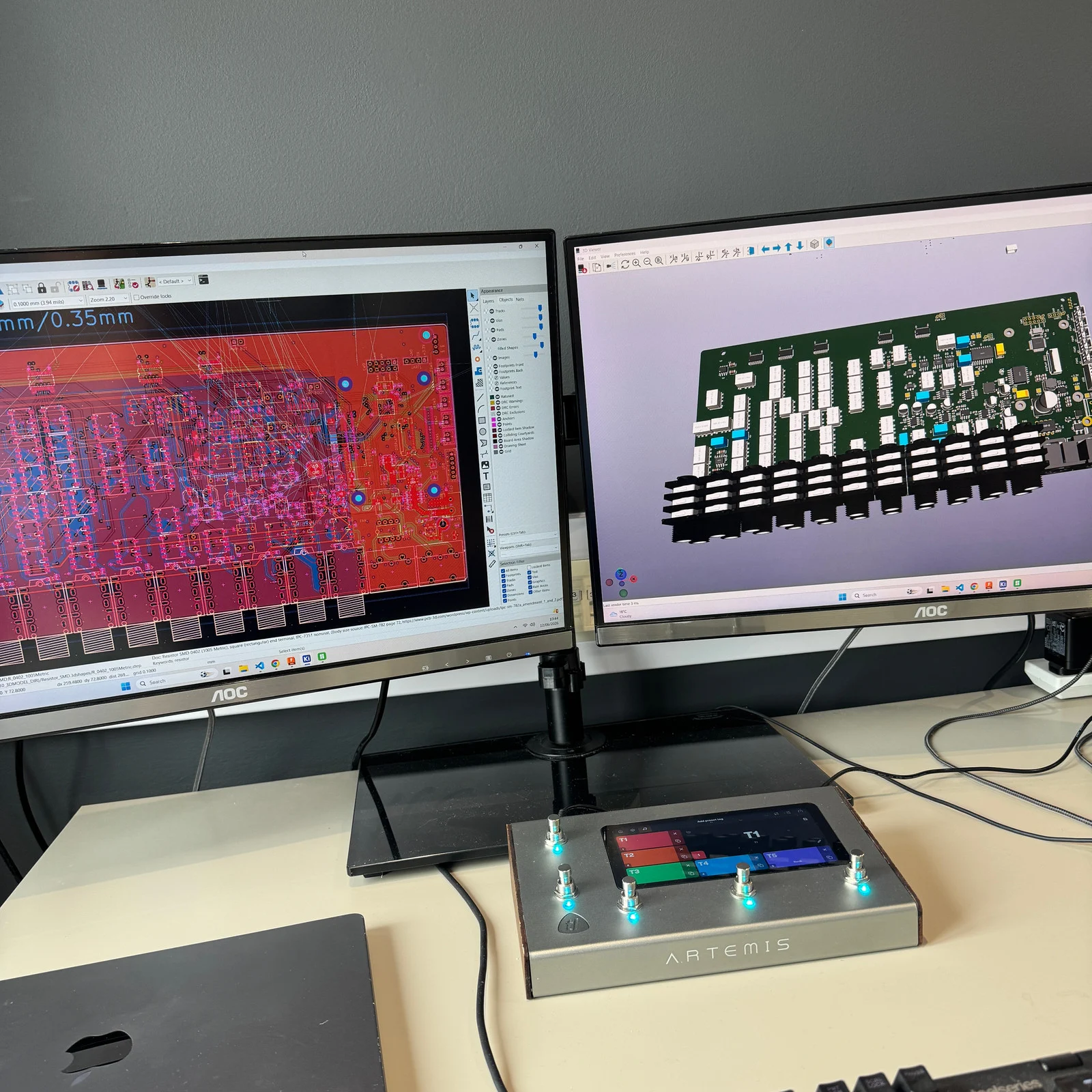 An Artemis prototype at the workbench, beneath monitors showing its circuit board design